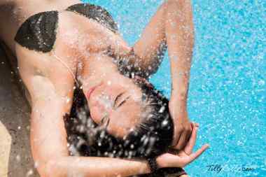 GIRL laying on pool and enjoying the weather and the water breeze